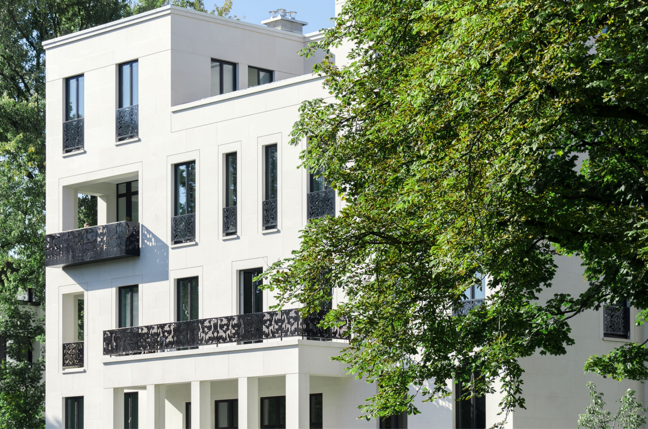 Façade of an Alster villa with balconies between old trees